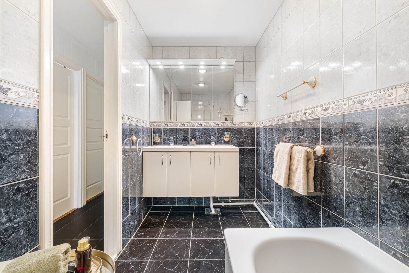 Delikat flislagt baderom med tidløse materialvalg og elektriske varmekabler i gulvet. Galleribilde