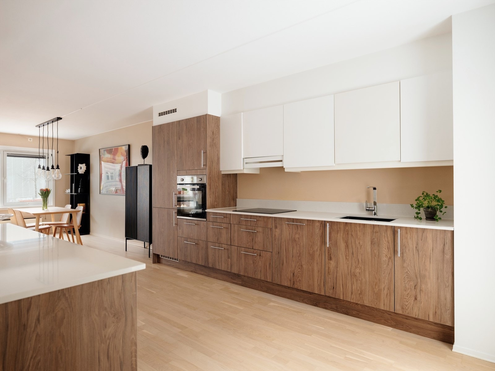 Det delikate kjøkkenet ble oppgradert i 2025/26 er innredet med glatte fronter og benkeplate i stein. Her har du rikelig med skap- og benkeplass å boltre deg på. De hvite frontene på overskap spiller godt mot frontene i tre. Galleribilde