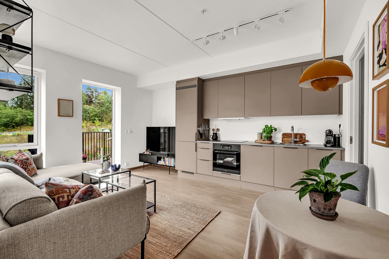 Kjøkkenets fronter er i en mørkere farge enn resten av stuen som skaper en tydelig kjøkkensone. Galleribilde