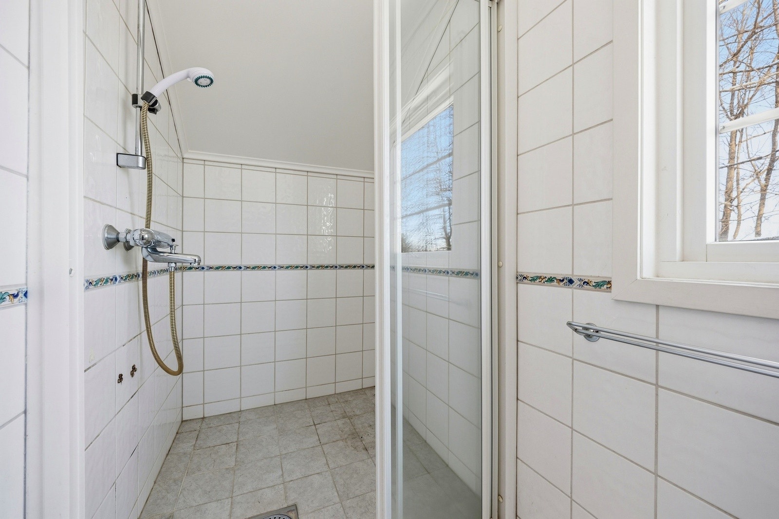 Flislagt bad med vegghengt servant og dusjhjørne. Galleribilde