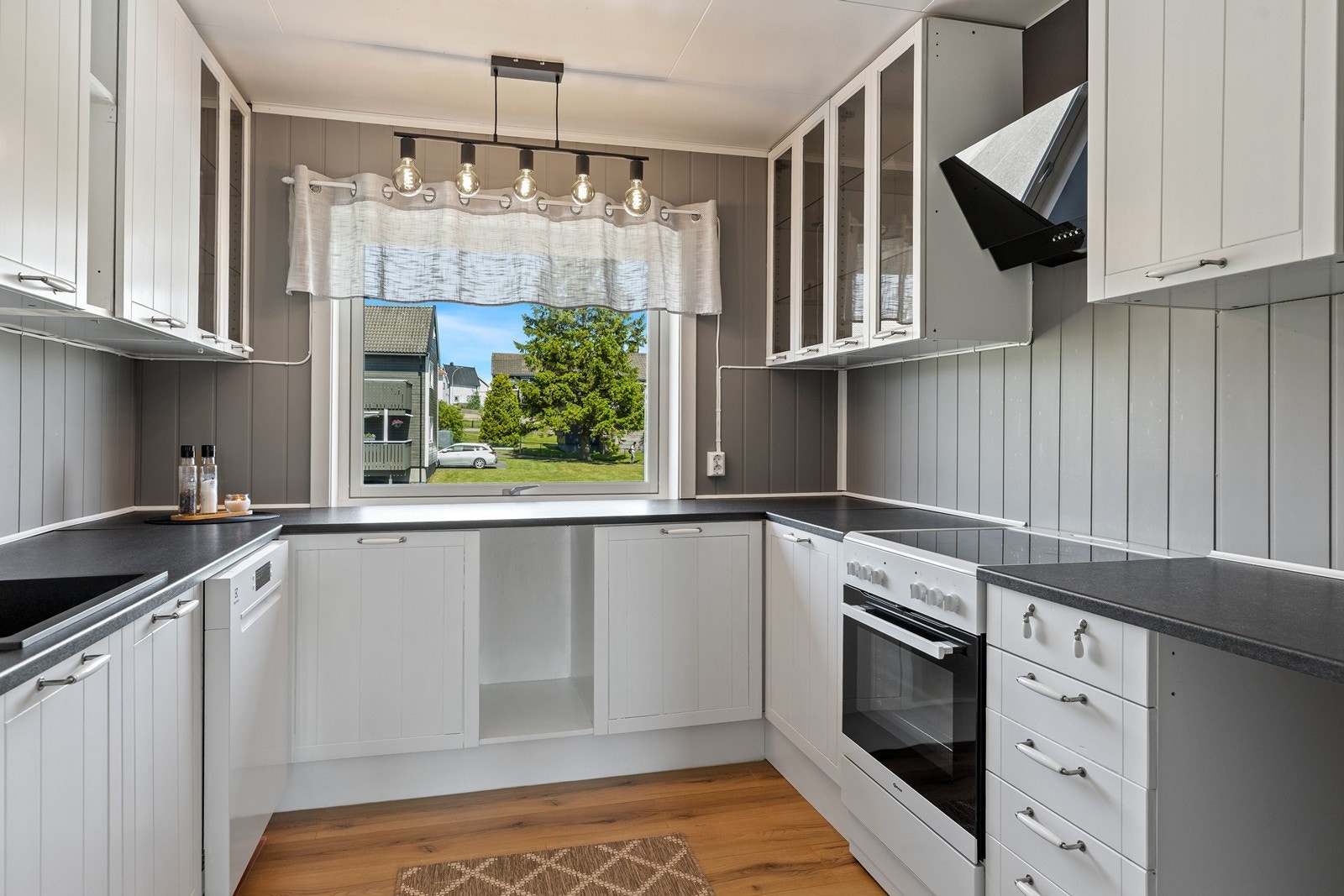 Lyst og klassisk kjøkken med mye skap og benkeplass Galleribilde