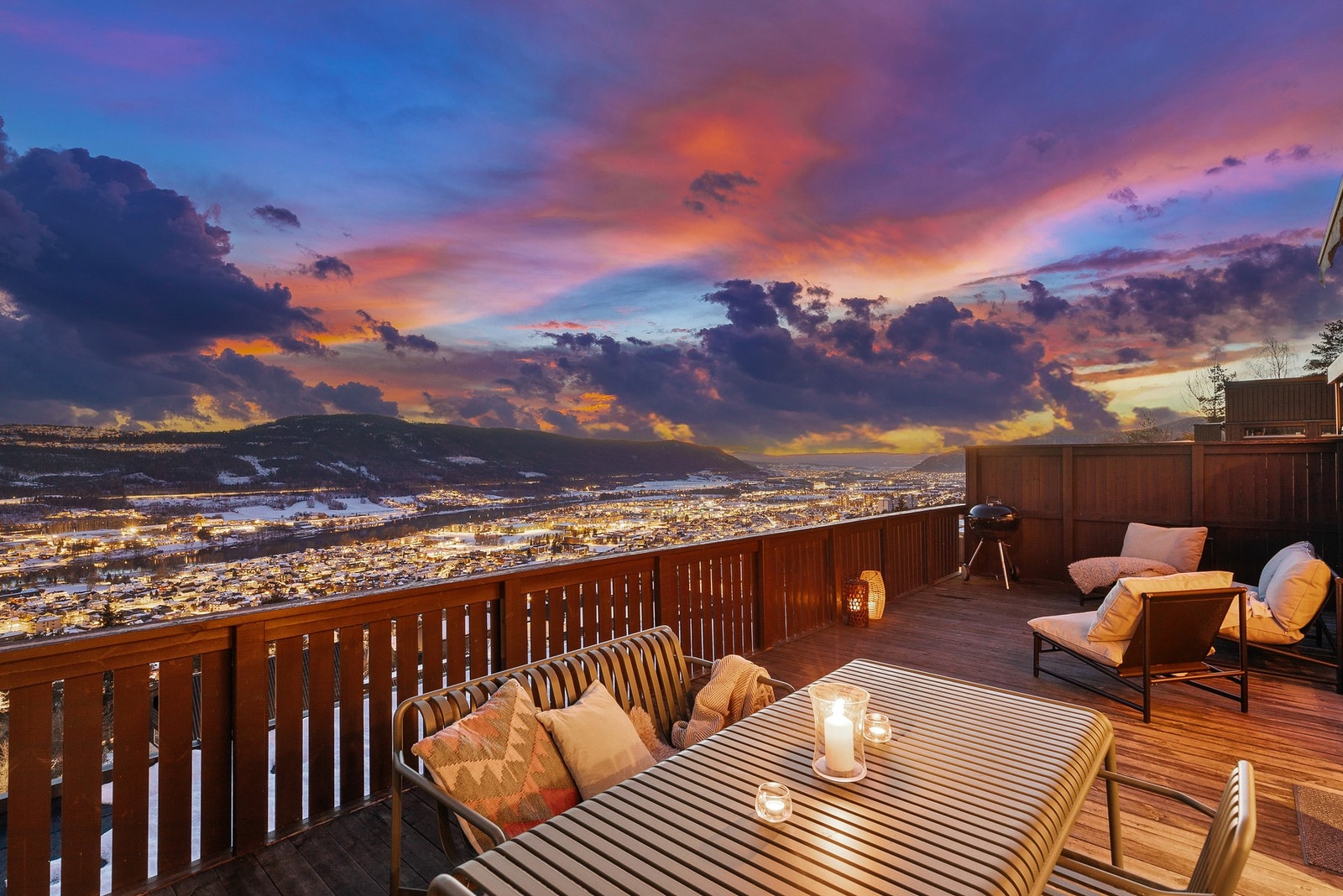 Stor og solrik terrasse med god plass til spisegruppe, lounge, solsenger og beplantning - alt rammet inn av en spektakulær panoramautsikt over byen og dalen Galleribilde