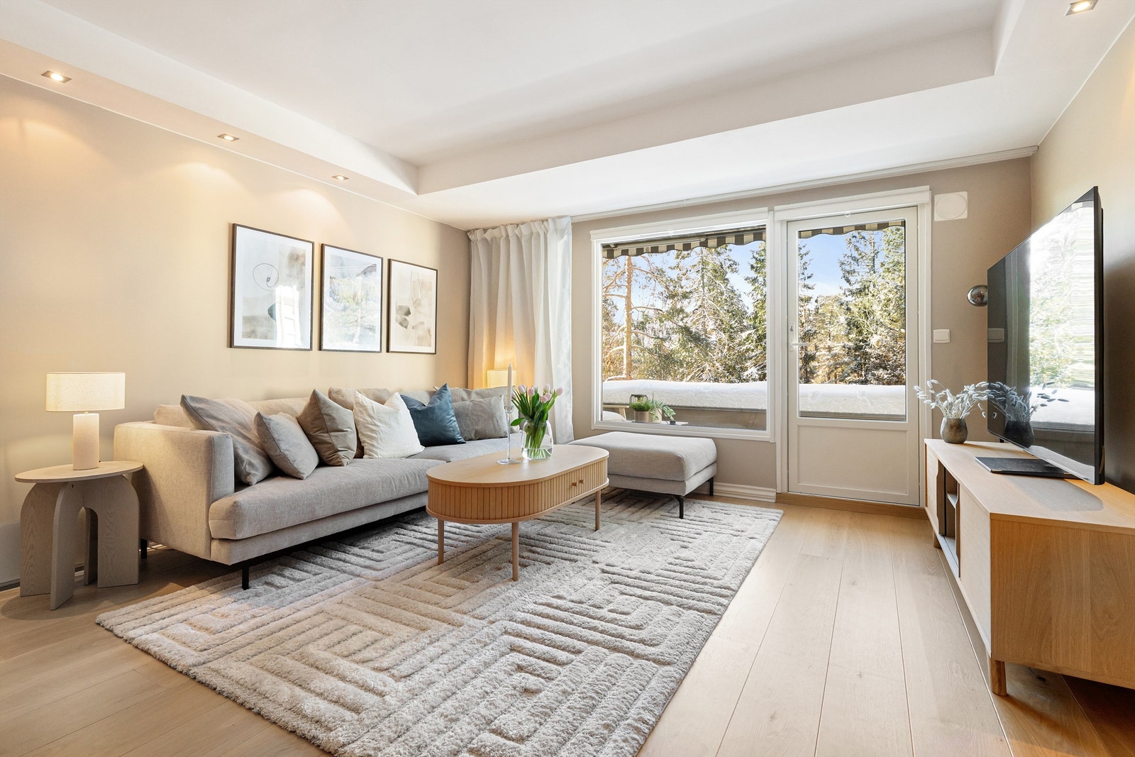 Stuen har glatte, malte flater, gjennomgående parkettgulv og store vinduer som gir en usjenert atmosfære uten innsyn. Galleribilde