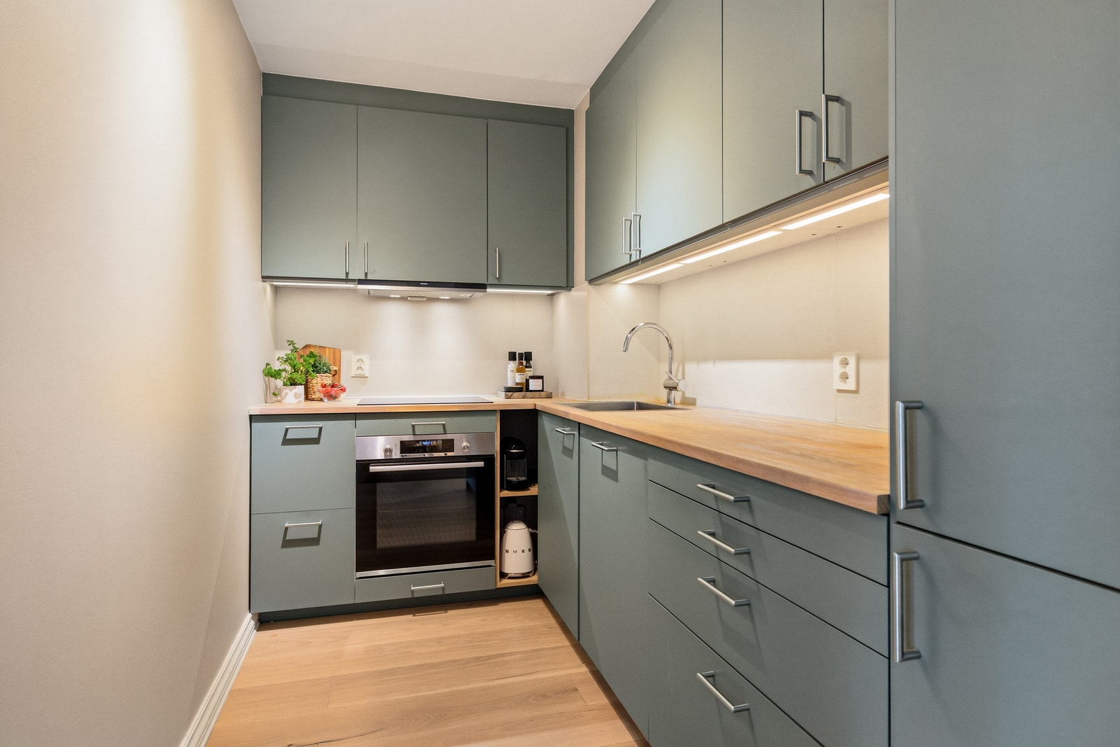 Moderne kjøkken fra 2020 med slette fronter, heltre benkeplate og rikelig med skap- og benkeplass. Foto: Trond Walsø / Walso Work Galleribilde