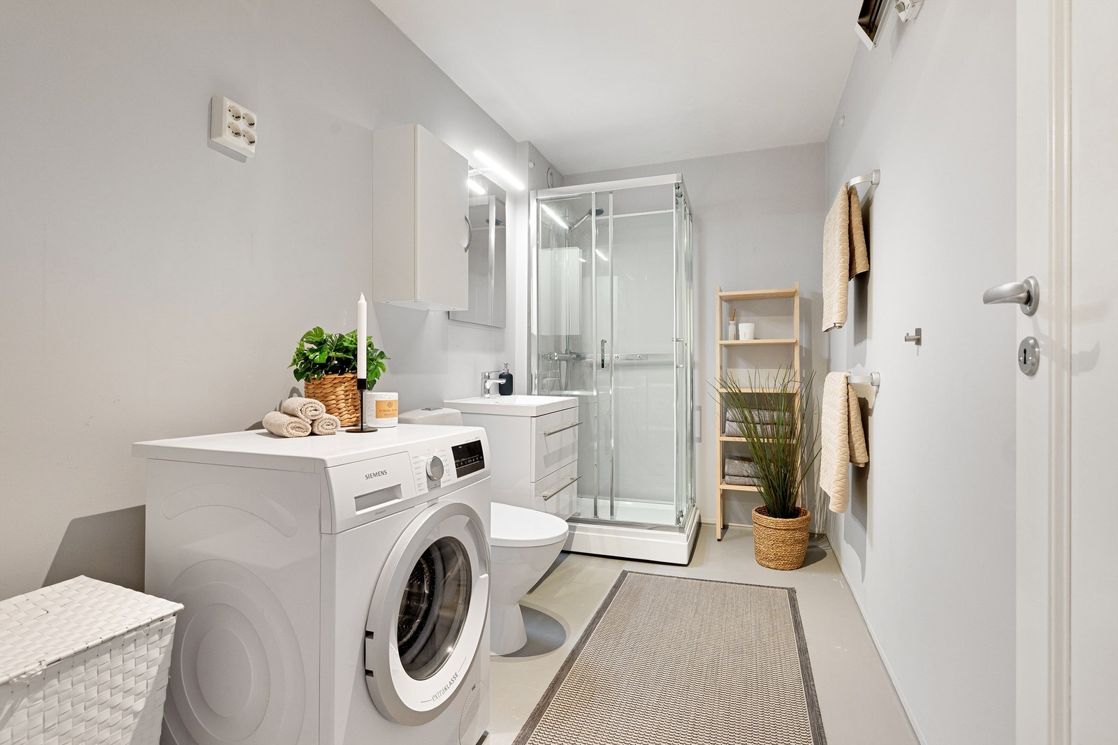 Baderommet har malte flater og er utstyrt med dusjkabinett og opplegg for vaskemaskin. Vaskemaskin medølger. Galleribilde