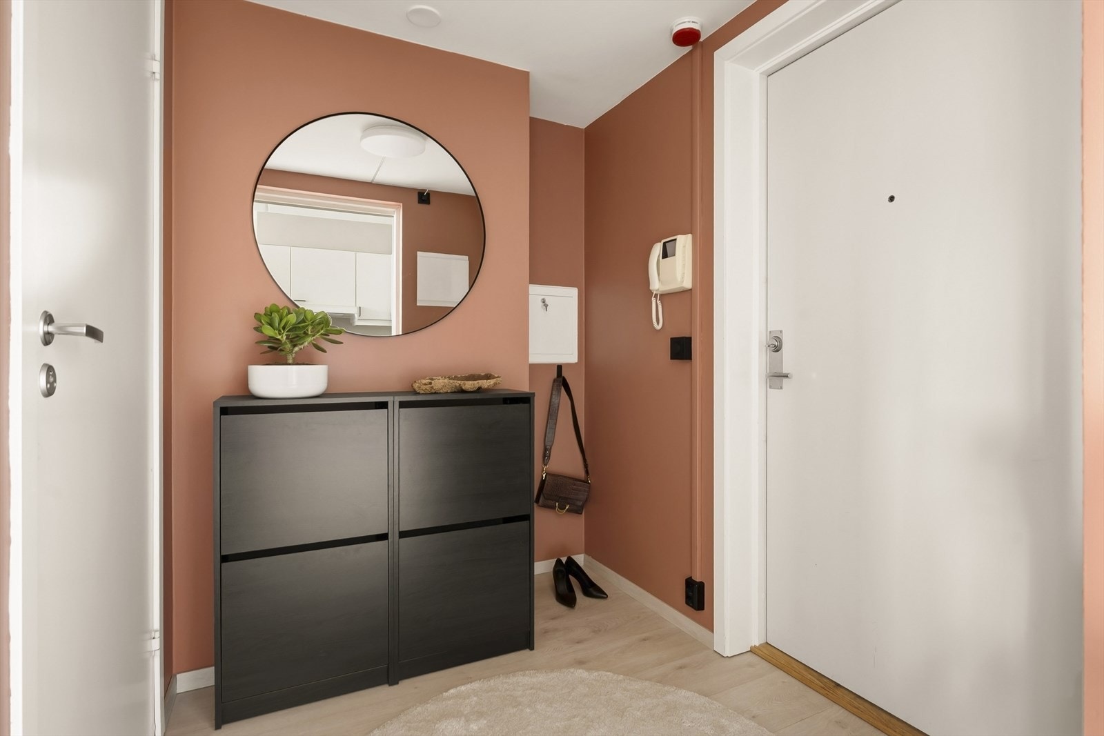 Velkommen inn i en praktisk entré med glatt malte vegger og laminat på gulvet. Galleribilde