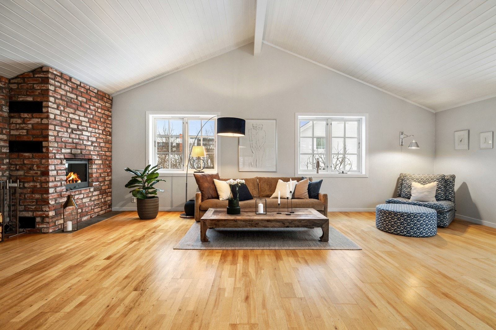 Stuen er lys og innbydende med en imponerende takhøyde som skaper et luftig og romslig oppholdsrom. Galleribilde