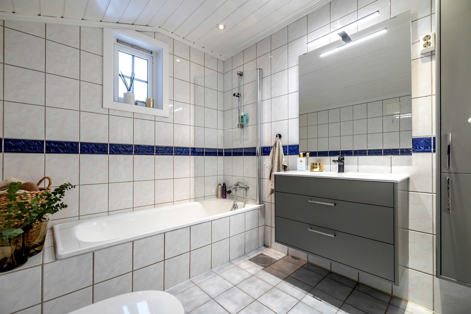Badet i første etasje er romslig og har flislagte vegger og gulv i lyse farger. Galleribilde