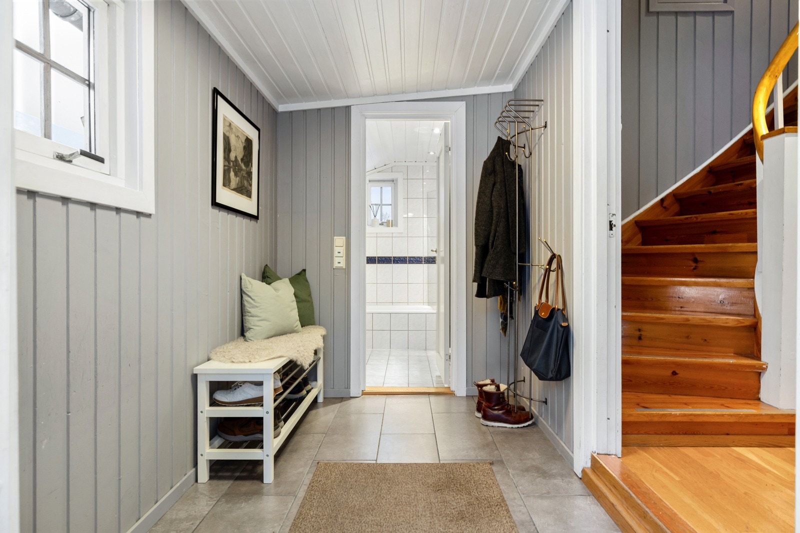 Boligen ønskes velkommen via en innbydende entré med flislagt gulv og gode oppbevaringsmuligheter for yttertøy og sko. Galleribilde