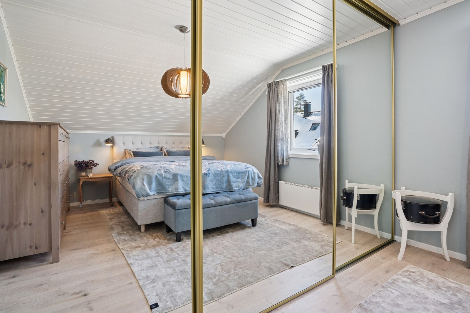 Lyst og innbydende soverom i delikate, rolige fargetoner, Stor skyvedørsgarderobe med speilfronter gir rikelig med oppbevaringsplass og forsterker romfølelsen. Galleribilde