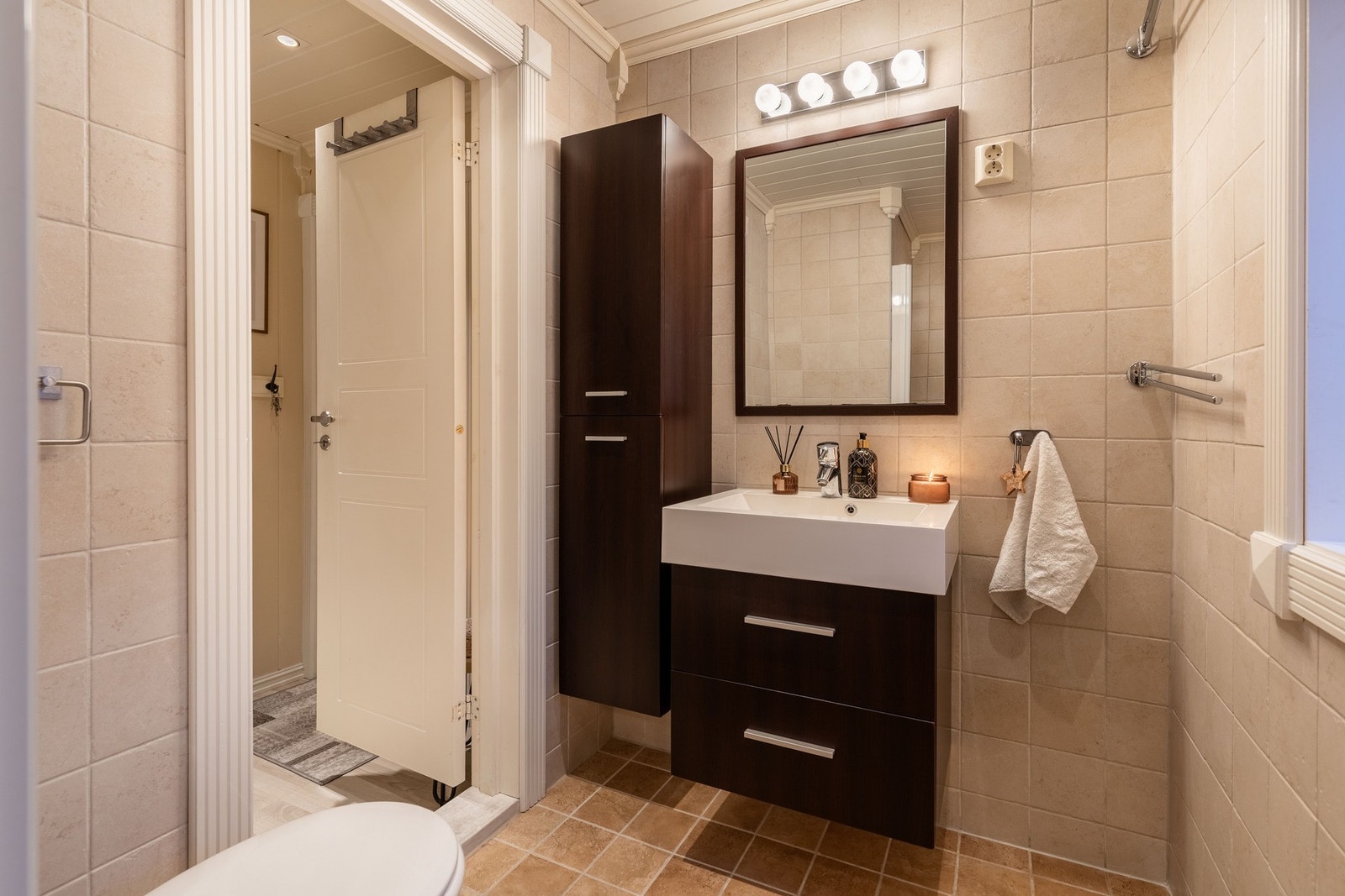 Badet fremstår pent og delikat med beige fliser på vegger og gulv i ulike nyanser som skaper et harmonisk uttrykk. Galleribilde