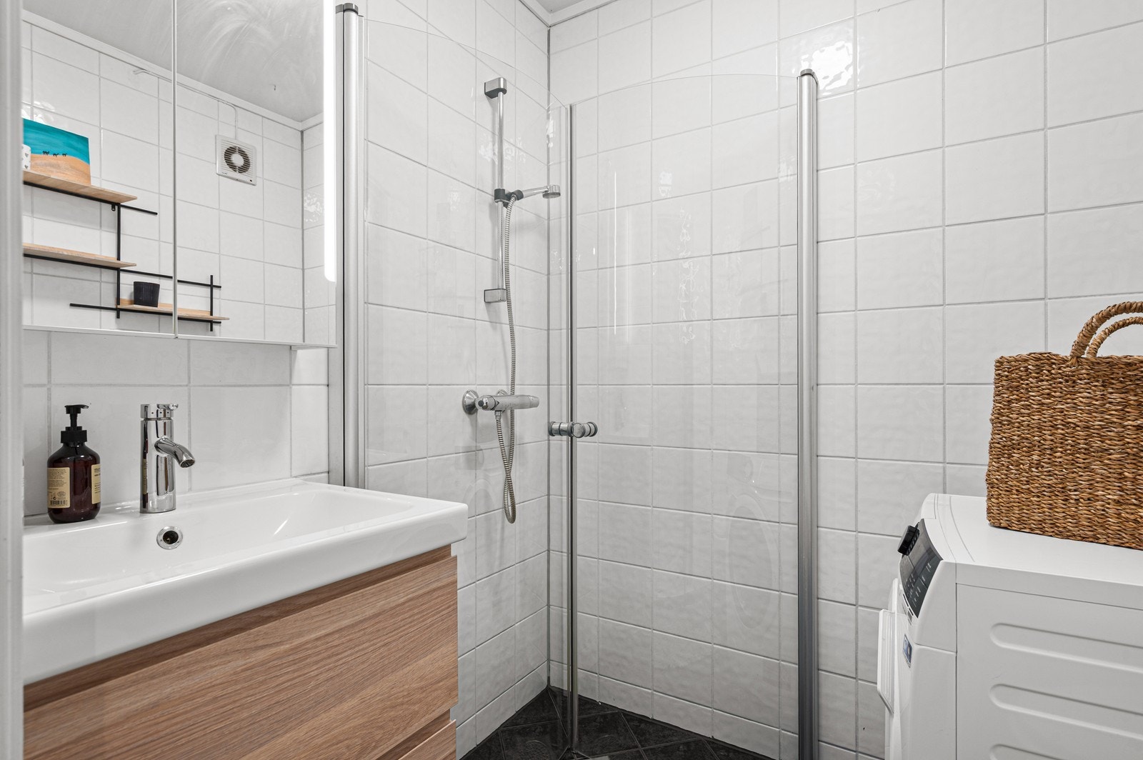 Lekkert flislagt bad med innfellbare dusjevgger for maksimal plassutnyttelse Galleribilde