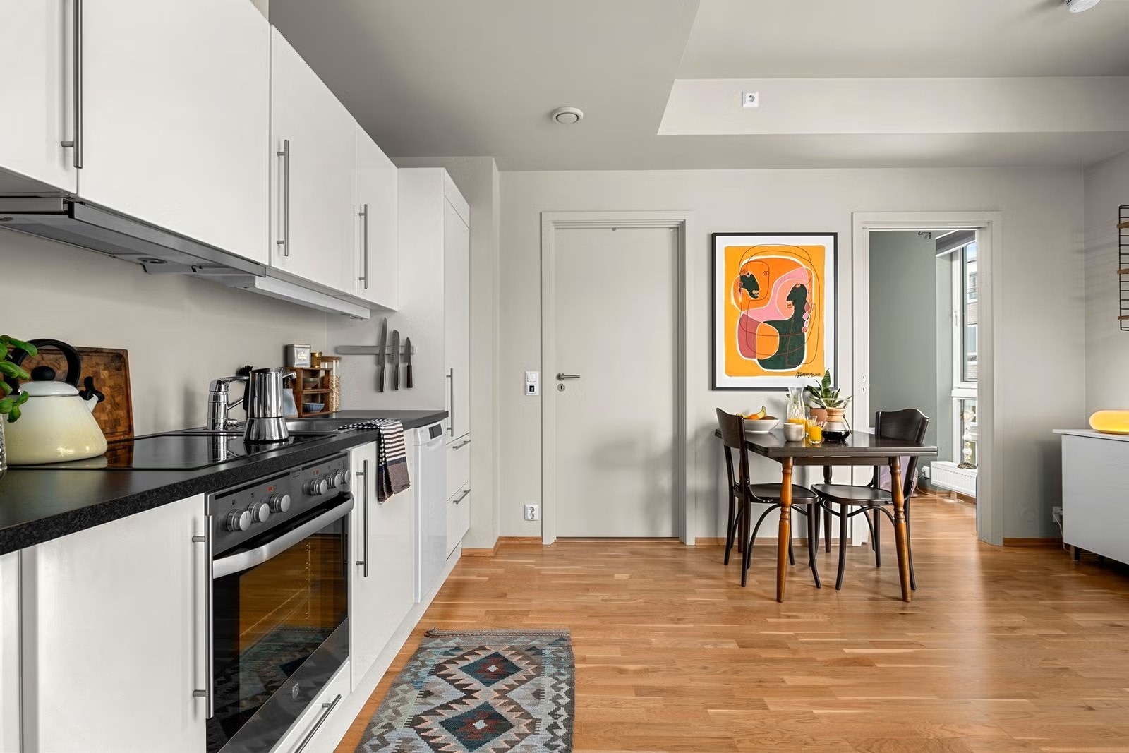 Kjøkkenet er innredet med kombiskap, komfyr, patetopp og oppvaskmaskin Galleribilde