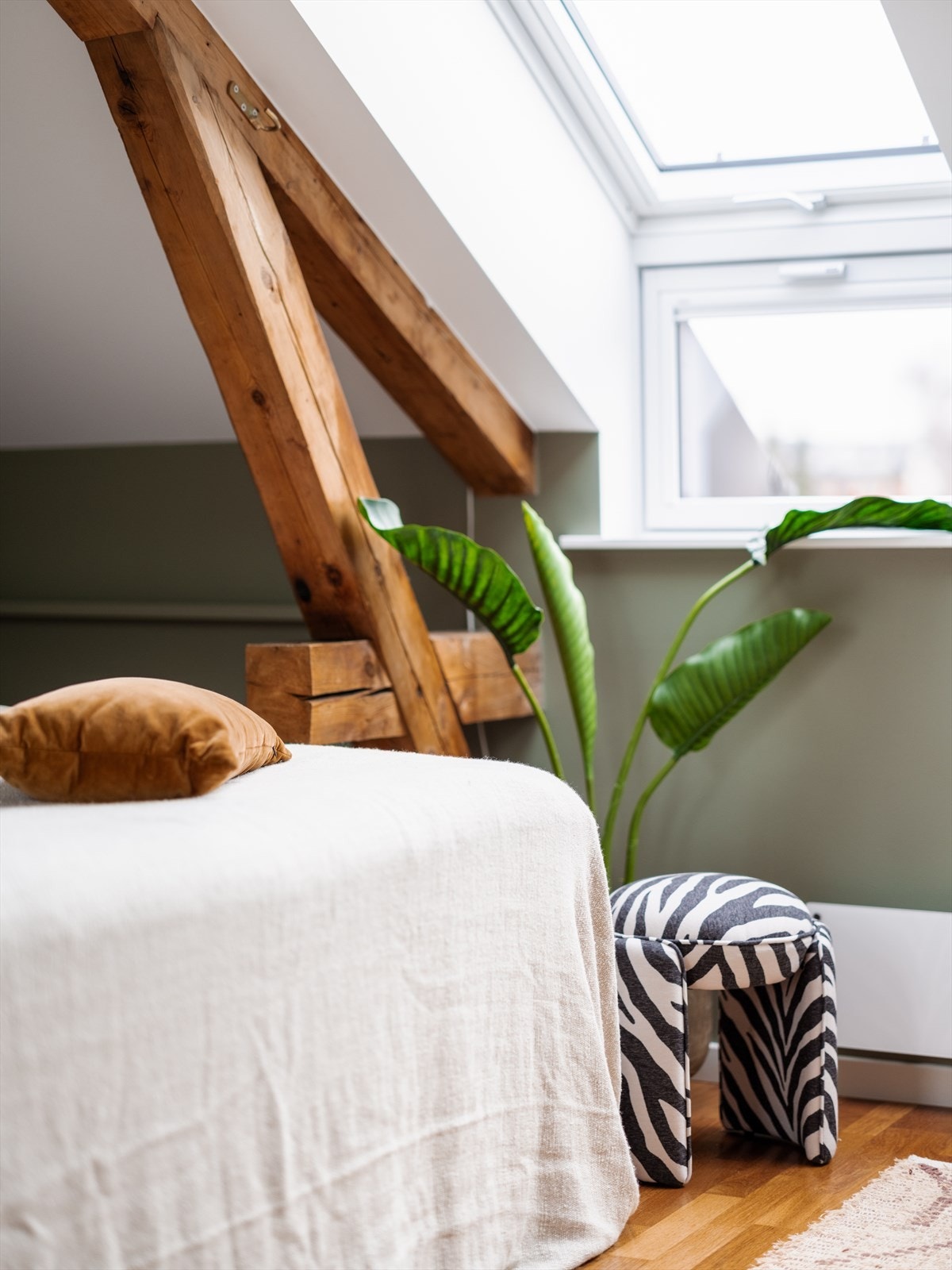 Synlige takbjelker går igjen i flere av rommene og gir leiligheten et gjennomgående og helhetlig preg. Galleribilde