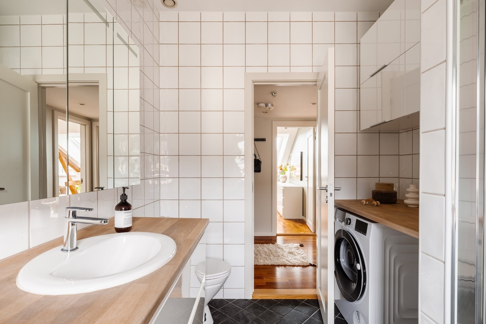 Badet byr på mye oppbevaringsplass og opplegg for vaskemaskin under benkeplaten. Galleribilde