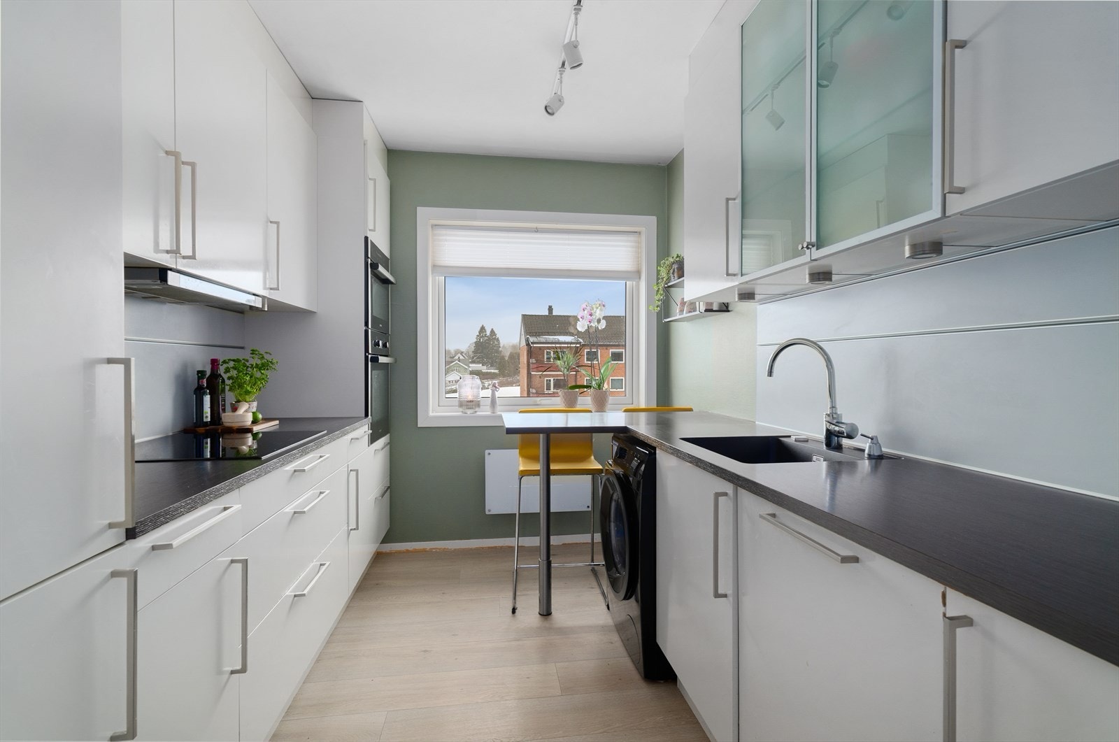 Kjøkkenet har innredning på to sider som består av over- og underskap, som gir rikelig med oppbevaringsplass samt gode arbeidsflater på kjøkkenbenken. Galleribilde