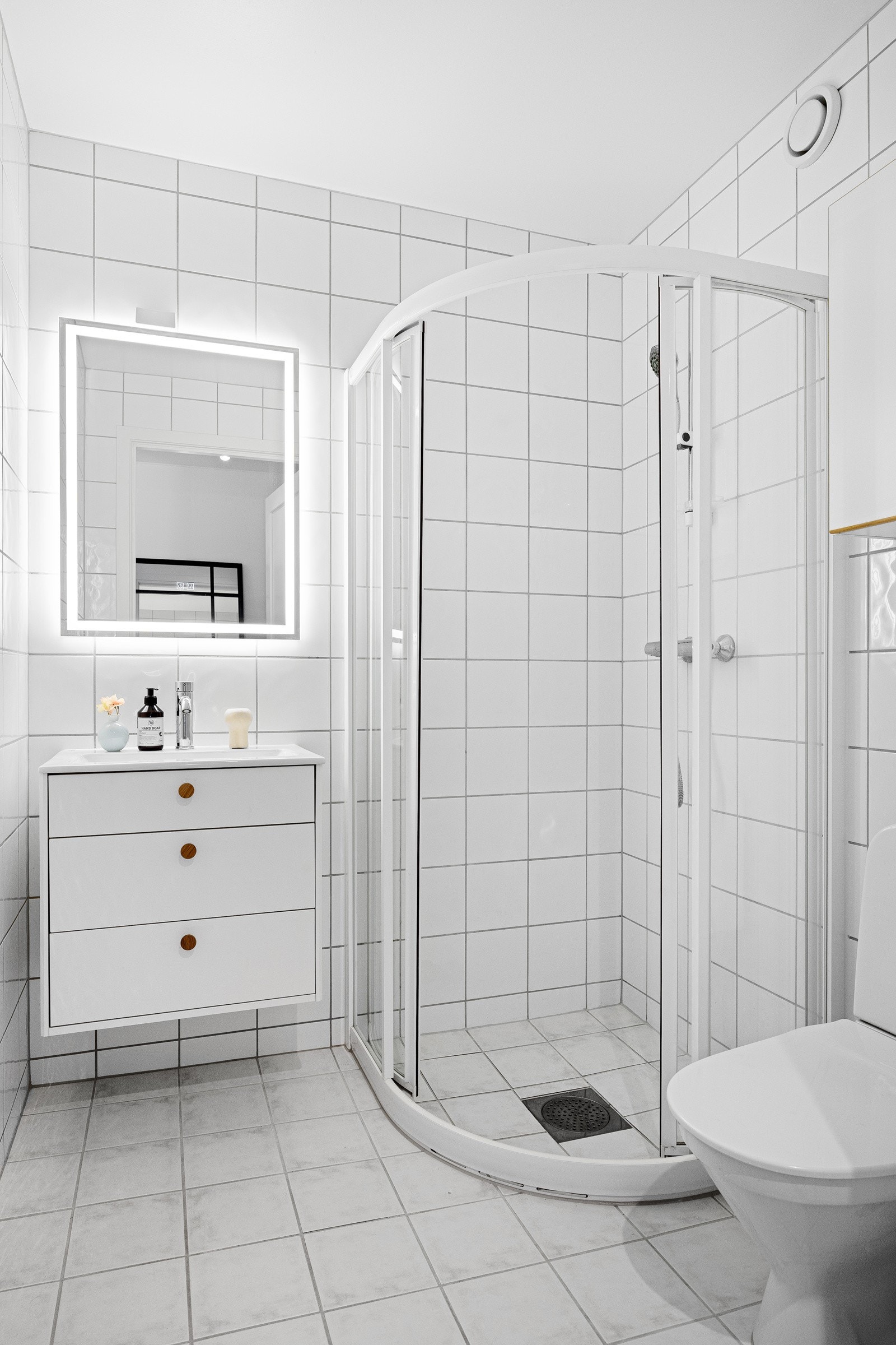 - Flislagt bad fra byggeår med dusjnisje med dusjvegger, toalett, servant med skap, vegghengt skap og speil med lys (nytt 2026) - Galleribilde