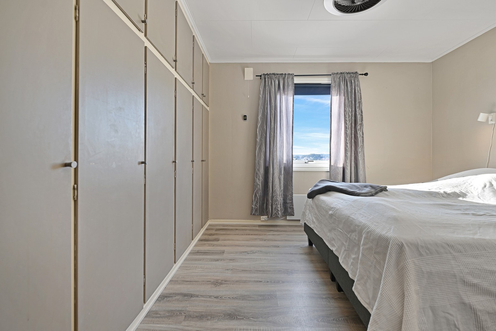 Soverom med innebygde skap, vindu med utsikt og lyse vegger. Galleribilde