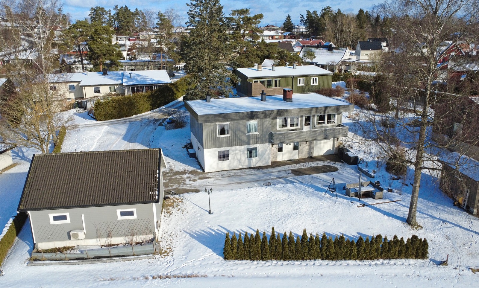 Bolig i et rolig nabolag med snødekt hage og garasje. Galleribilde