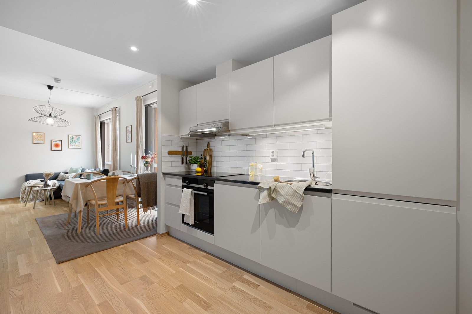 Stilrent og moderne kjøkken med grepsfrie fronter og flis mellom over- og underskap. Integrerte hvitevarer medfølger i handelen og inkluderer platetopp, stekeovn, kjøl/fryseskap og oppvaskmaskin. Galleribilde