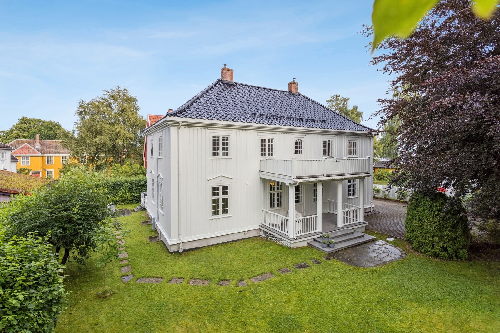 Den markante fasaden og den overbygde verandaen gir boligen et representativt og innbydende preg. Galleribilde