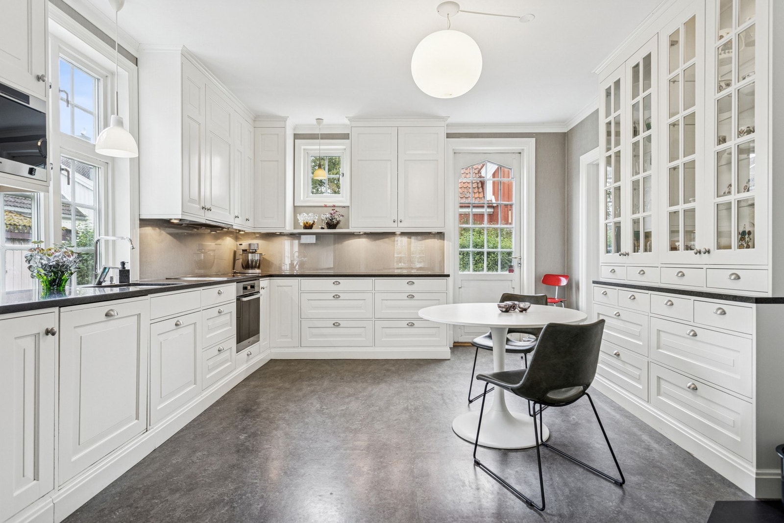 Stilrent og romslig kjøkken med klassisk Kjøkkeninnredning med profilerte fronter og naturstein benkeplater. Galleribilde