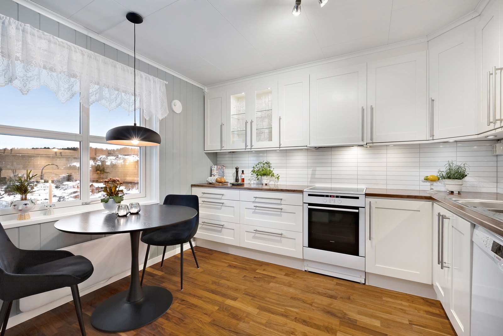 Kjøkkenet har lys innredning med profilerte fronter og benkeplate i laminat Galleribilde