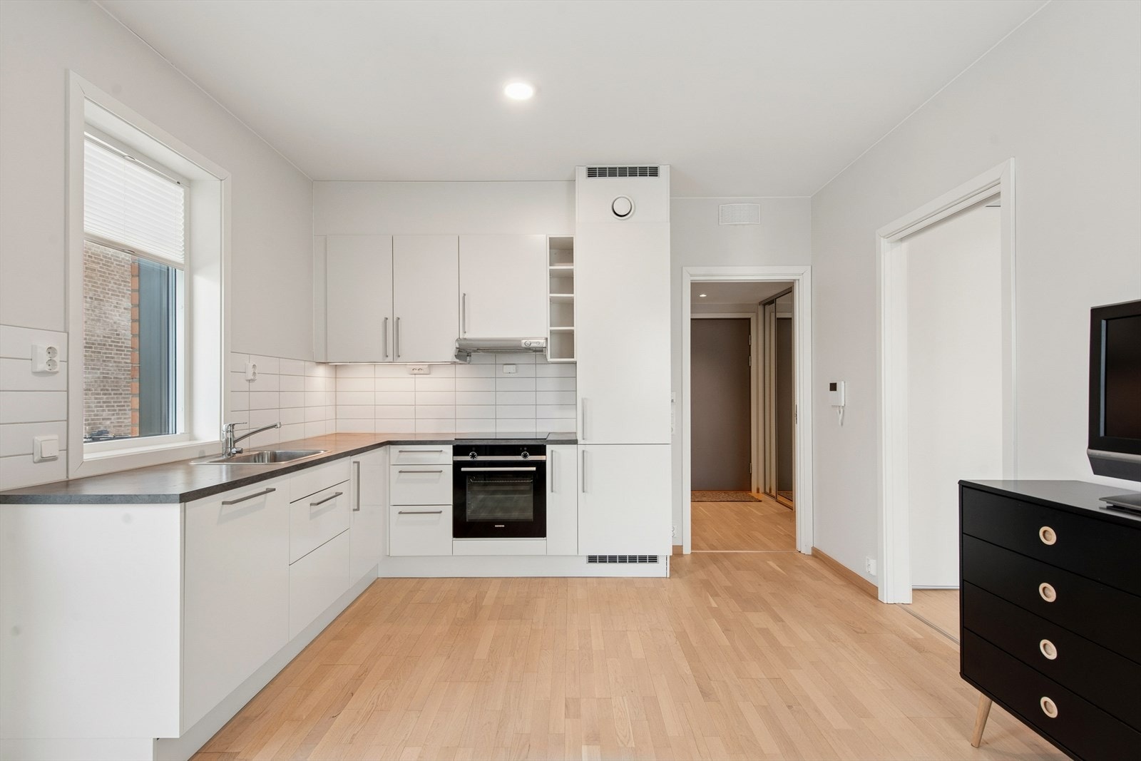 Det er belysning under overskapene, som gir gode arbeidsforhold. I benkeryggen er det lagt hvite fliser. Galleribilde