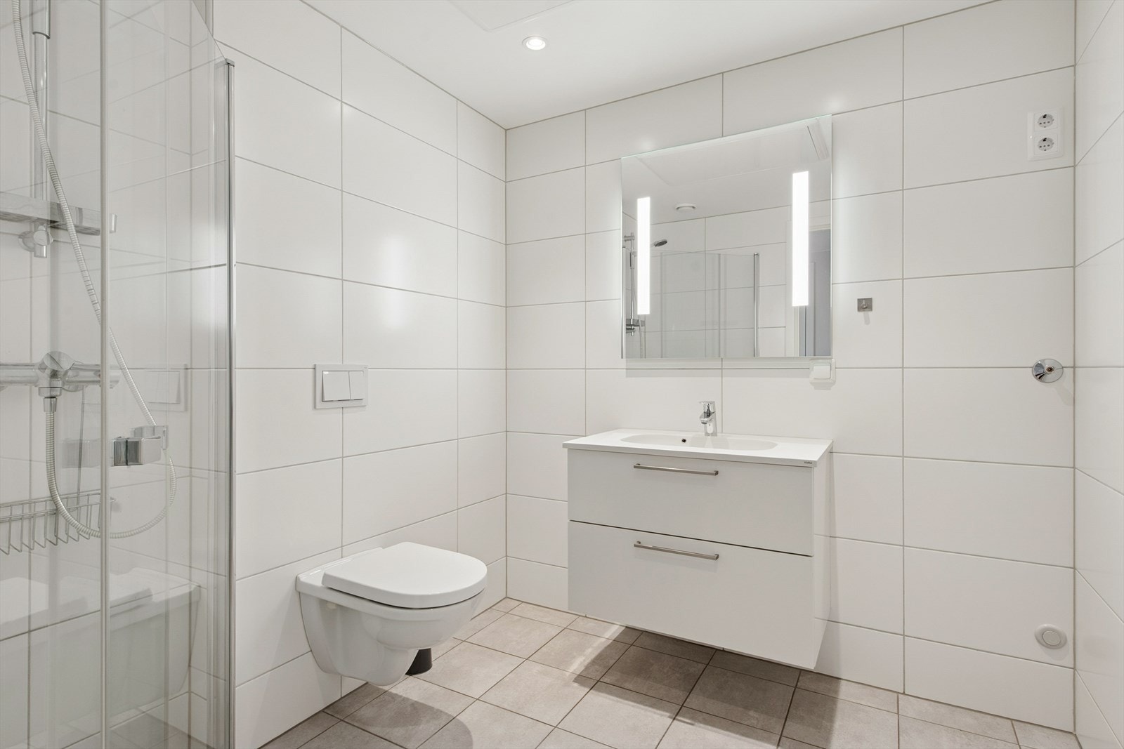 Flislagt baderom fra 2019 med gulvvarme for økt komfort. Himlingen består av malte plater med innfelte spotter. Galleribilde