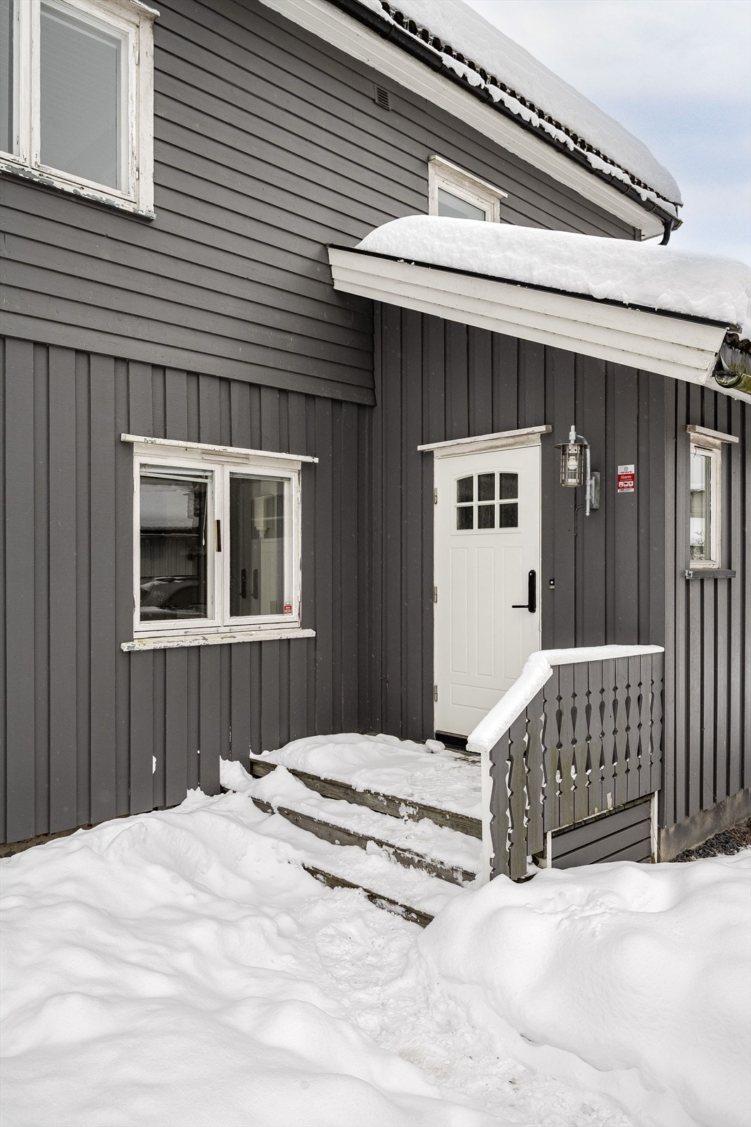 Boligen ble tilbygget med entré og bad i 1987. Praktisk med kodelås montert på ytterdøren og utebelysning på vegg. Galleribilde