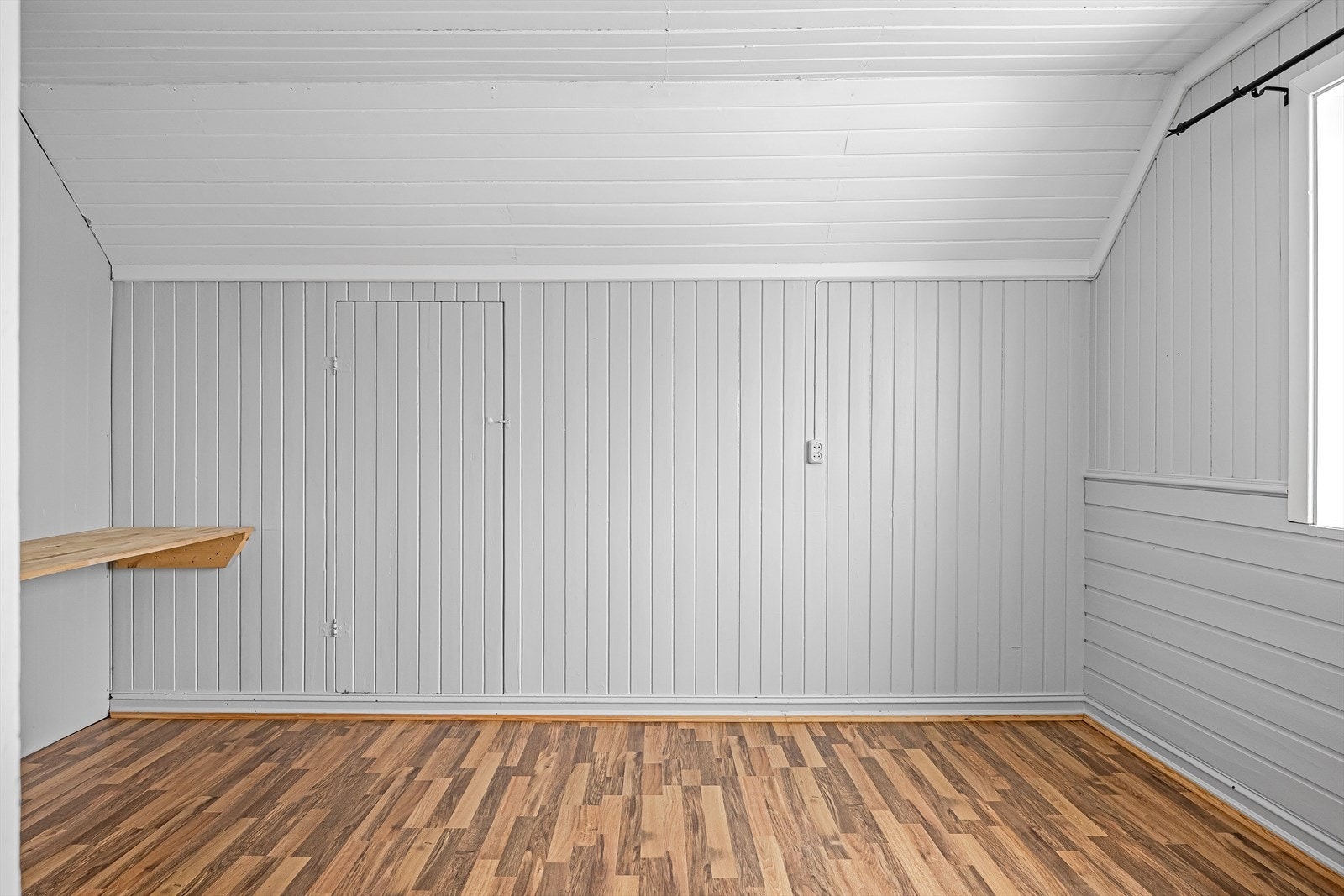 Soverommet har laminatgulv og overflater malt i en lysegrå farge. Galleribilde