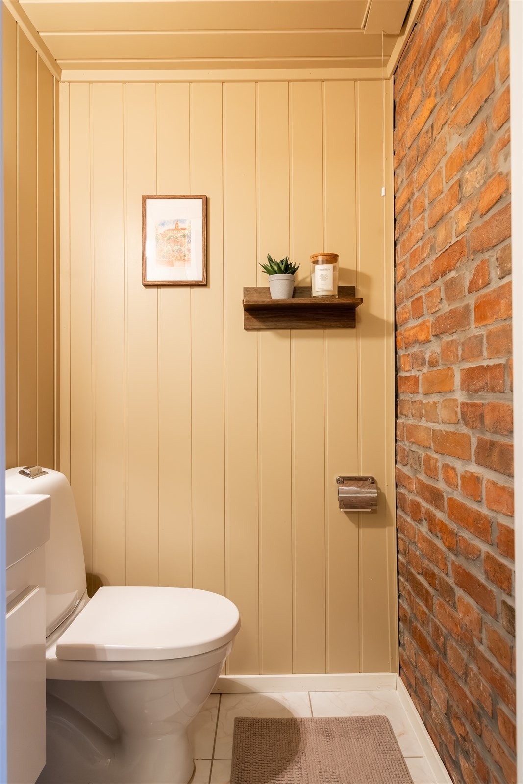 Toalettrom med toalett og servant med underskap. Galleribilde