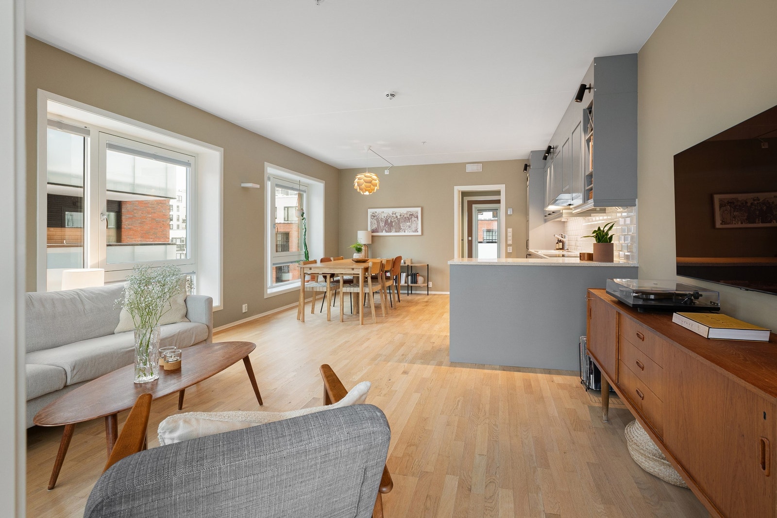 Lys stue med flere, store vinduer som slipper inn rikelig med dagslys Galleribilde