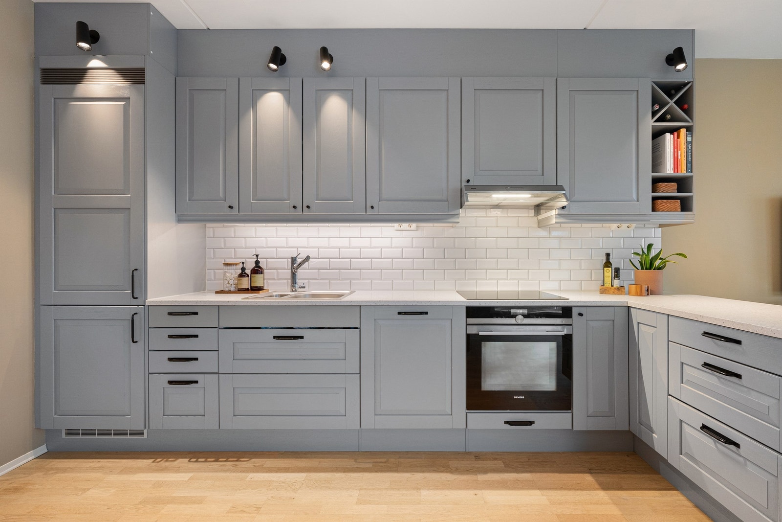 Strøkent kjøkken med åpen og sosial løsning mot stue. Kvalitetsrik kjøkkeninnredning fra Sigdal med profilerte fronter og påkostet lekker Corian benk. Nyere koketopp, komfyrvakt og ventilator. Fliser mellom kjøkkenbenk og overskap Galleribilde