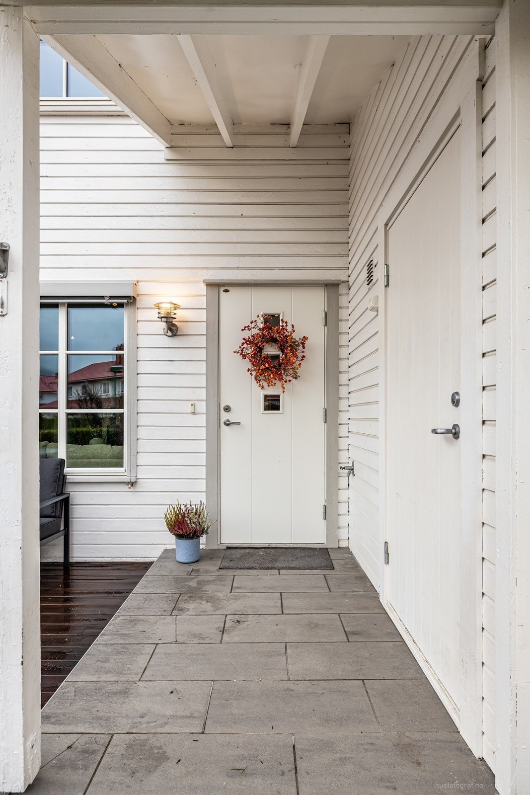 Adkomstvei belagt med belegningsstein til boligens flislagte og overbygde inngangsparti i 1. etasje. Galleribilde