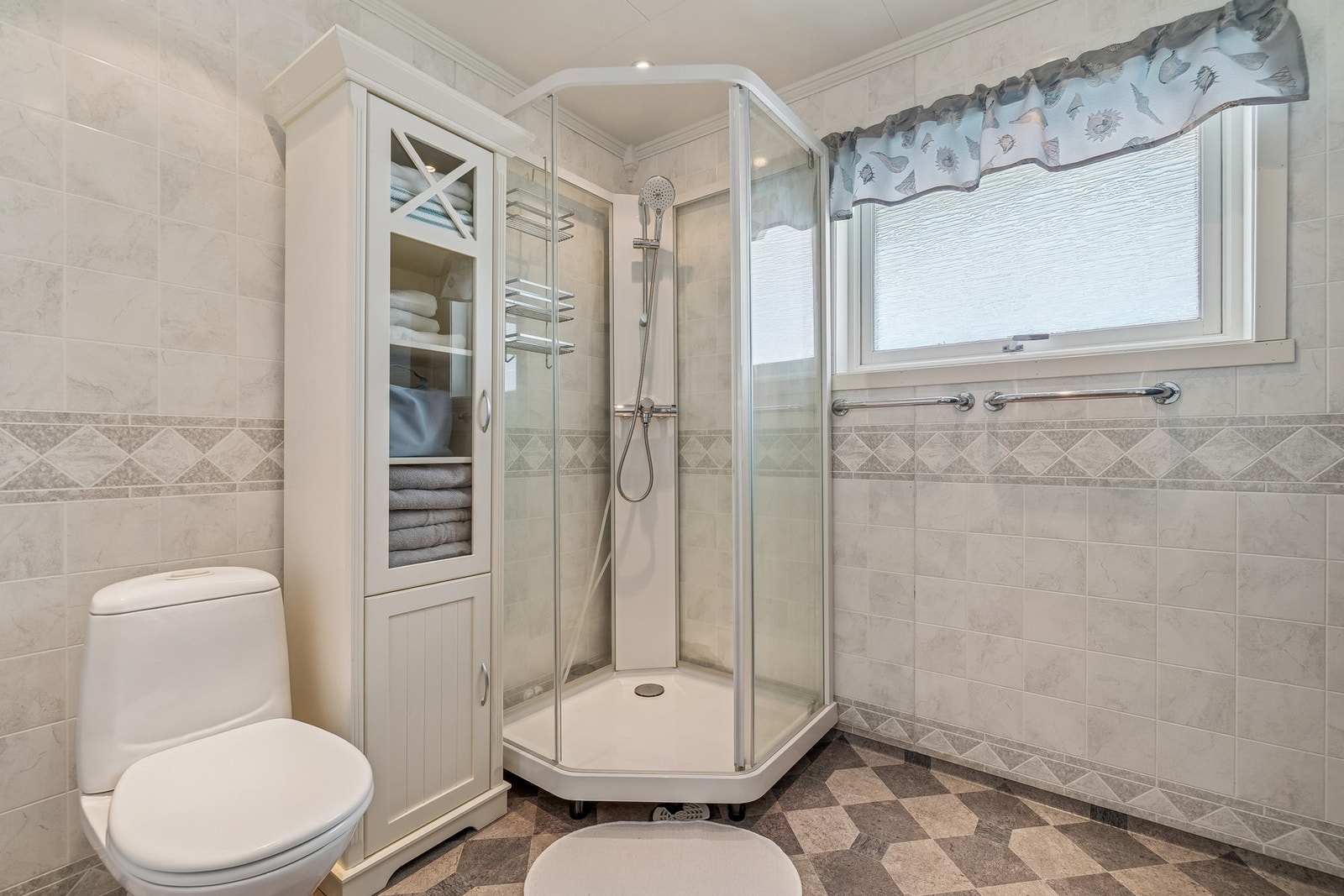 Badet har toalett, dusjkabinett og øvrig baderomsinnredning med servant. Galleribilde