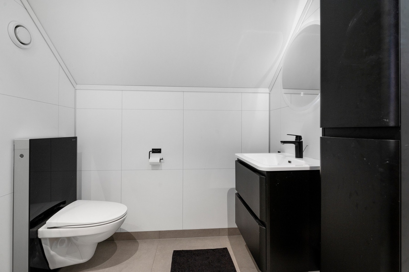 Lyst helfliset bad med mørk baderomsinnredning. Galleribilde