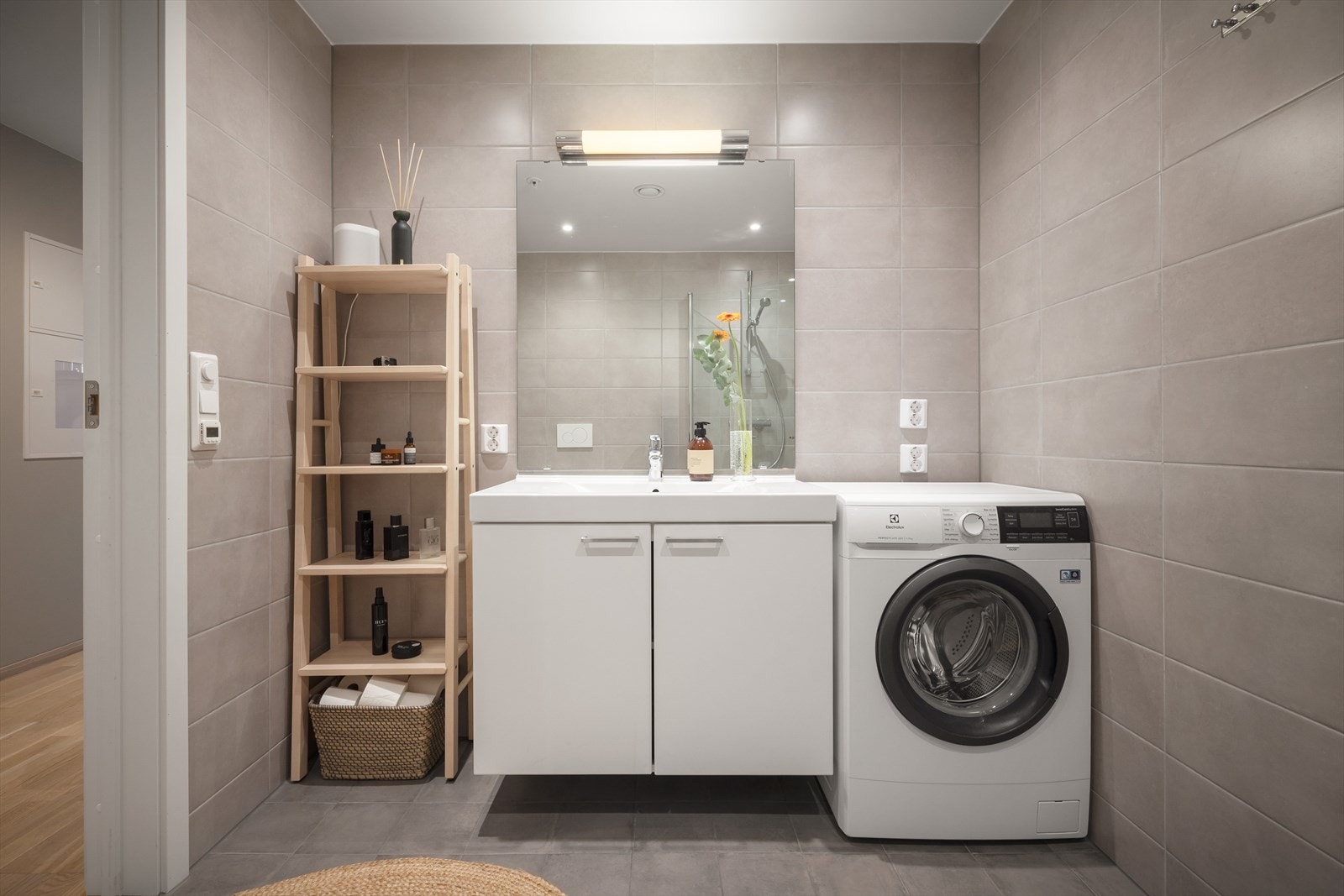 Servant med skuffeseksjon, speil med belysning og opplegg for vaskemaskin. Galleribilde