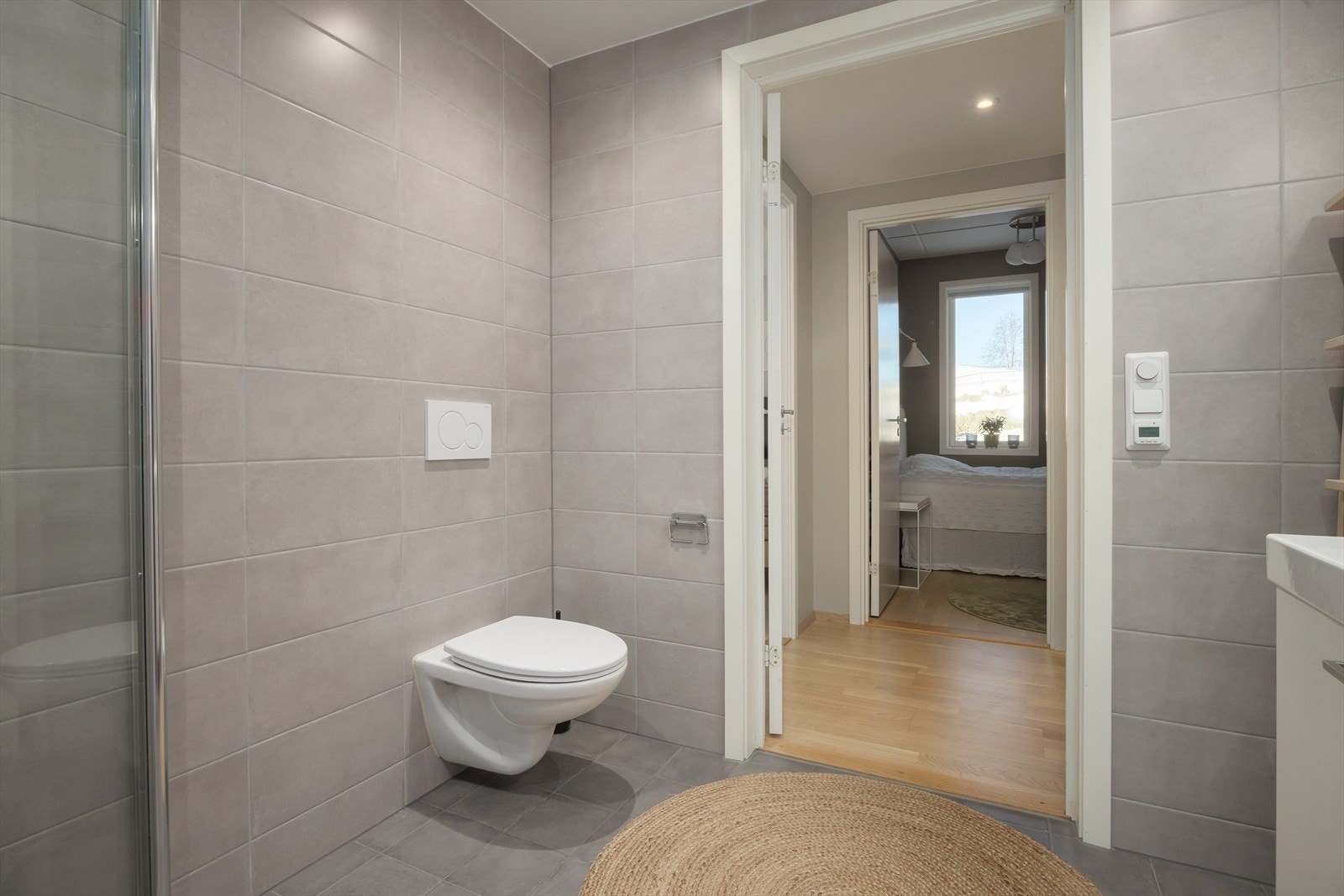 Vegghengt toalett og dusjhjørne med svingbare glassdører. Galleribilde