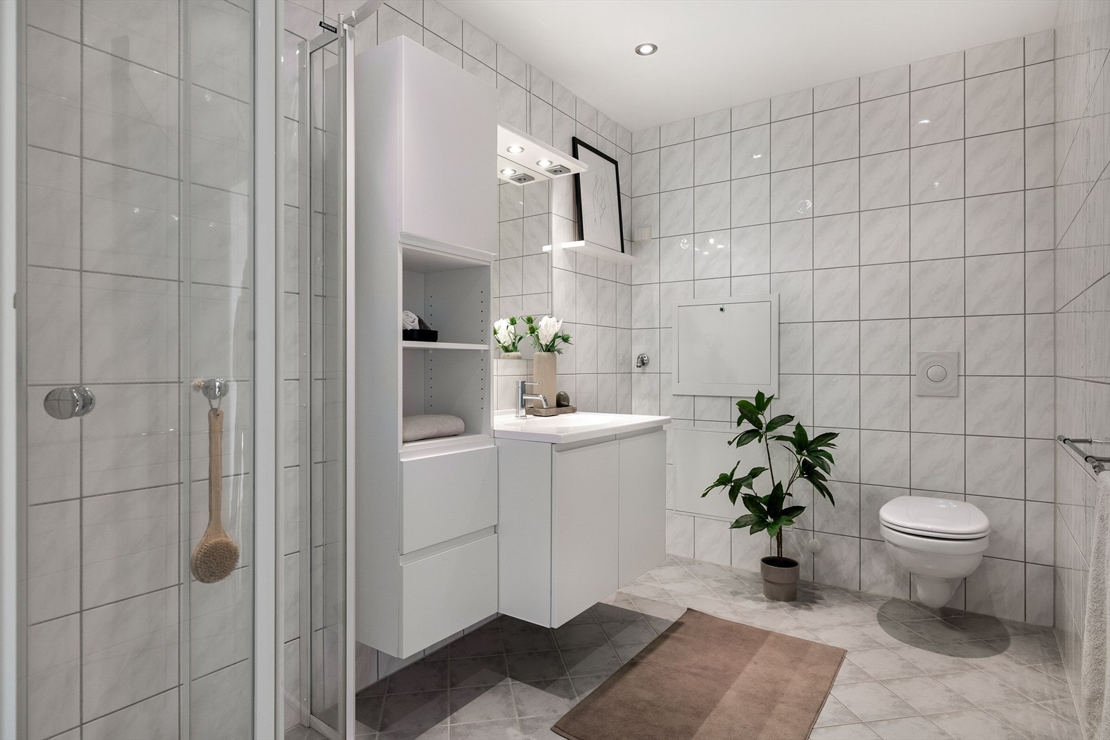 Flislagt bad med dusjnisje og opplegg for vaskemaskin. Galleribilde