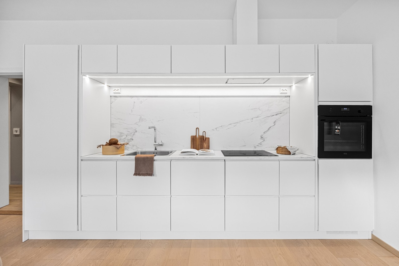 KVIK kjøkkeninnredning bestående av hvite skapfronter og integrerte hvitevarer. Galleribilde