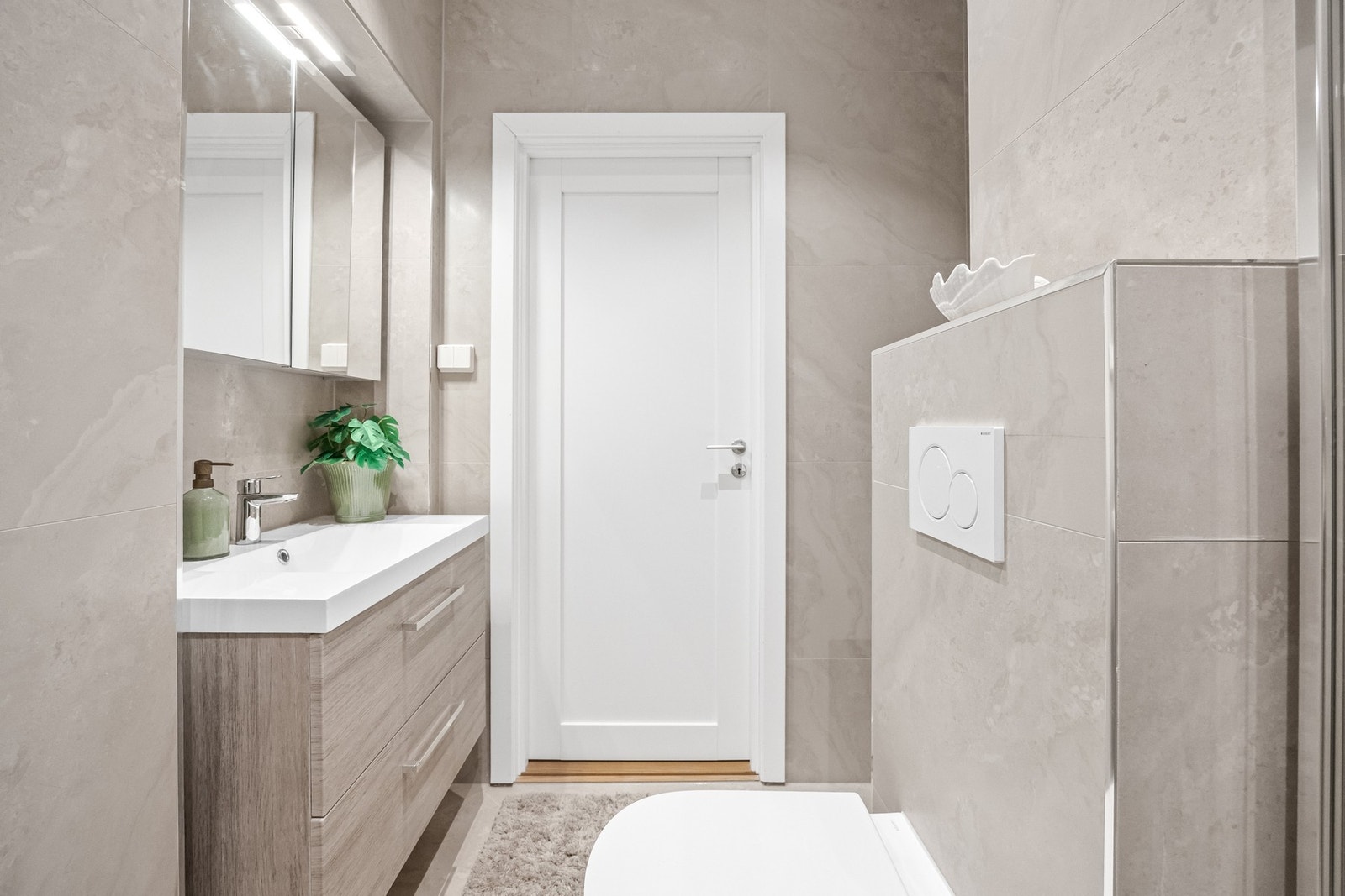 Speil hengende over vasken har hyller for toalettsaker, samt lys. Tilgang på stikkontakt ved servant. Galleribilde