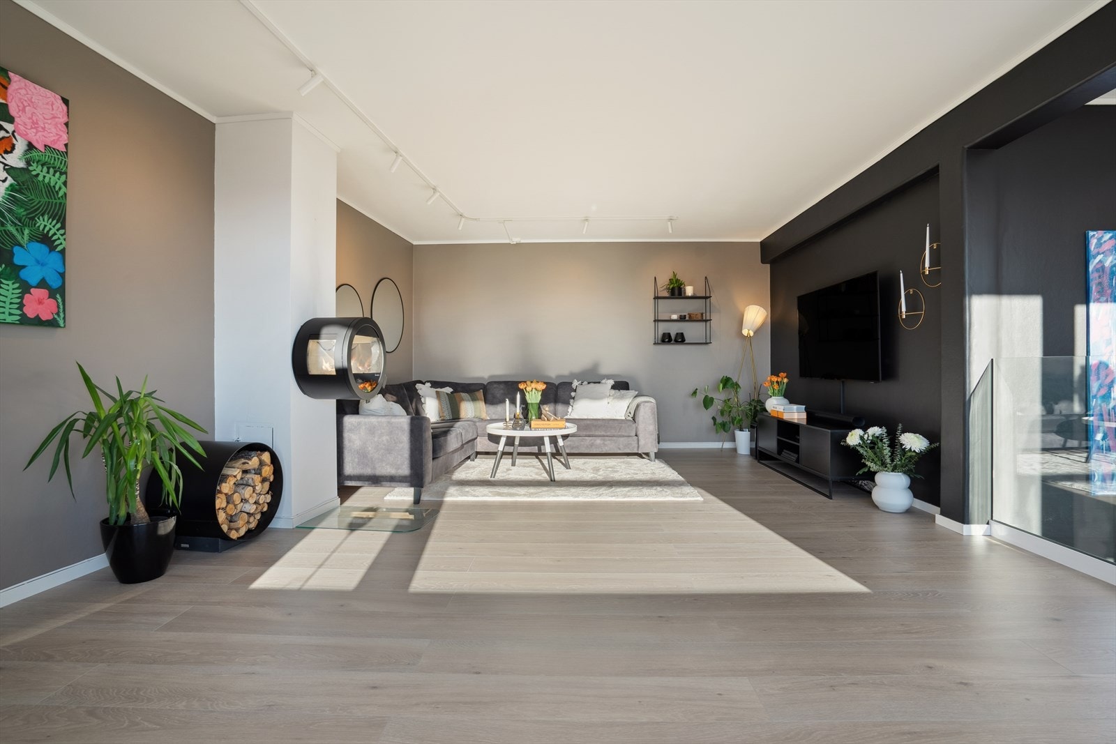 Stuen er romslig og utført i lyse overflater med belysning på skinner i himlingen og god plass til sittegruppe i sofakrok hvor tv-en finner sin naturlige plassering på veggen Galleribilde