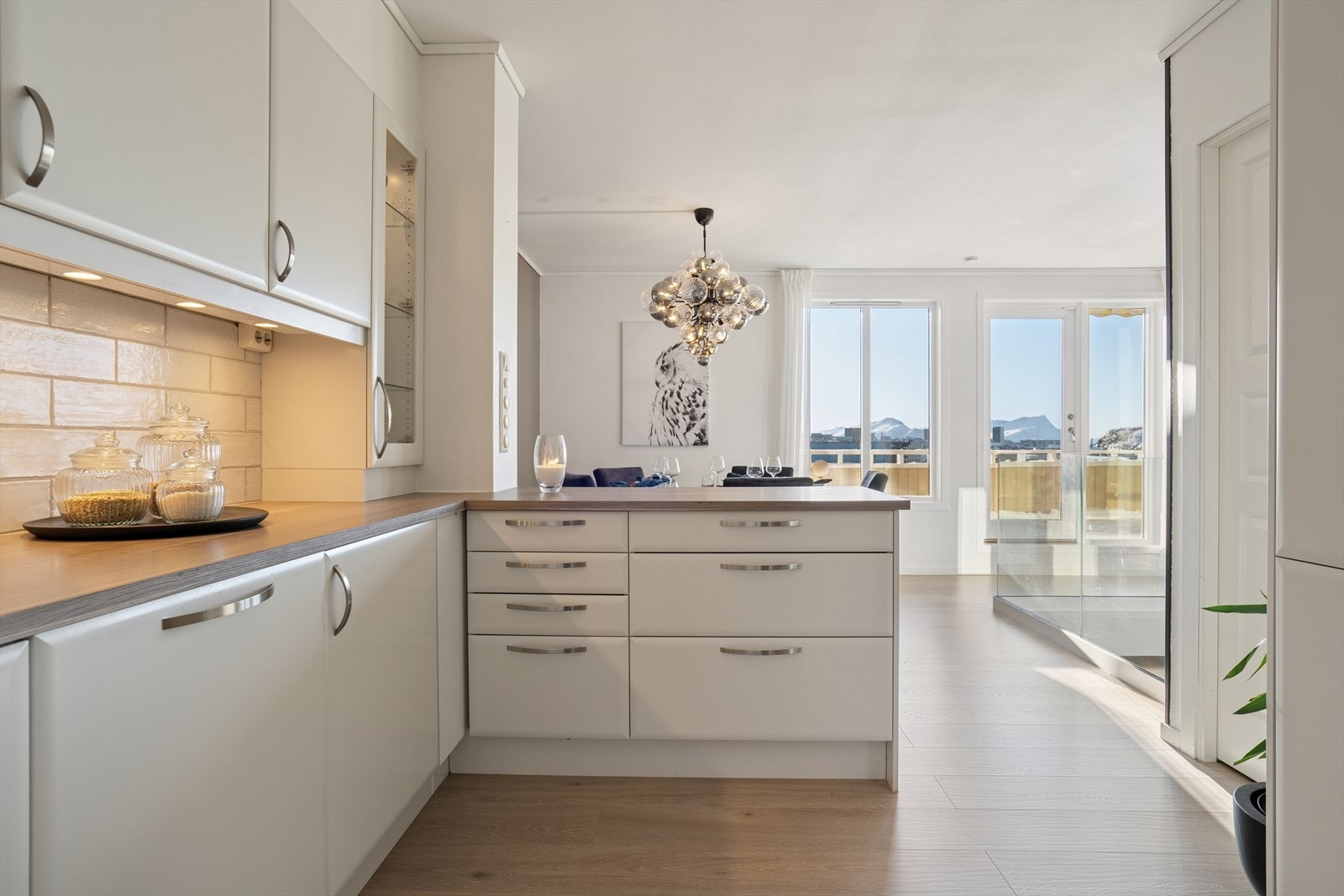 Kjøkkenet har lyse slette fronter og er meget godt utbygget med skap og benkeplass Galleribilde