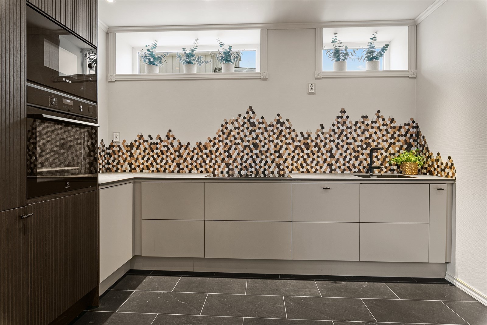 Pen innredning med integrerte hvitevarer og godt med oppbevaringsmuligheter Galleribilde