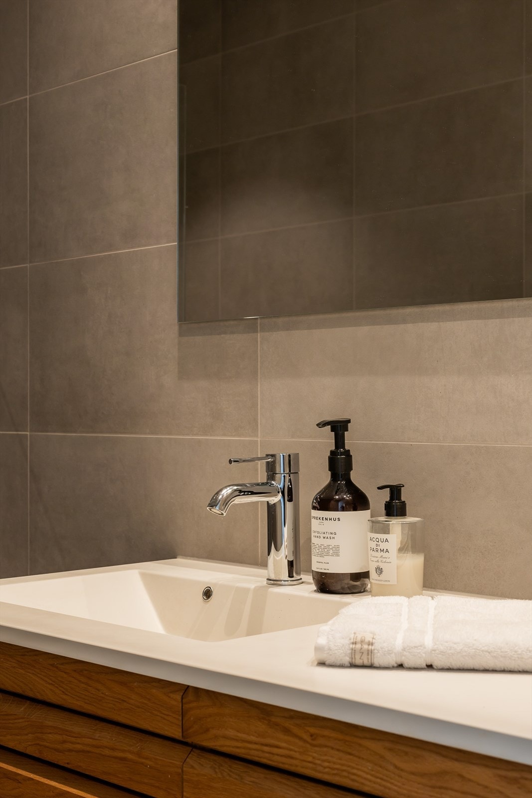 Innredning består av badekar med dusj, vegghengt toalett og servantskap med ovenpåliggende servant. Galleribilde