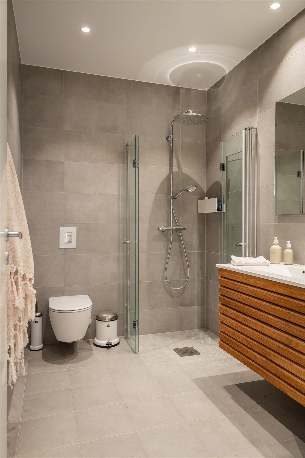 Forøvrig er badet innredet med vegghengt toalett og dusjhjørne utstyrt med både hånd- og regnfallsdusj. Galleribilde