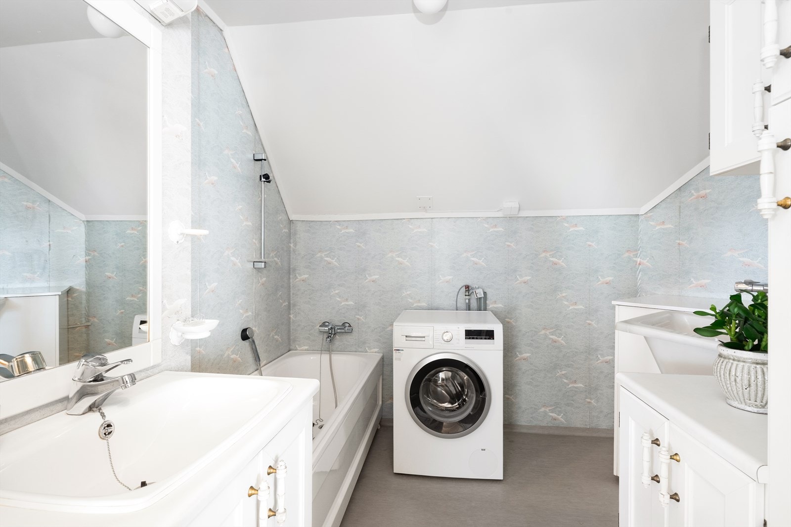 Badet innehar badekar, vaskekum og servantinnredning med profilerte fronter. Det er også opplegg for vaskemaskin. Galleribilde