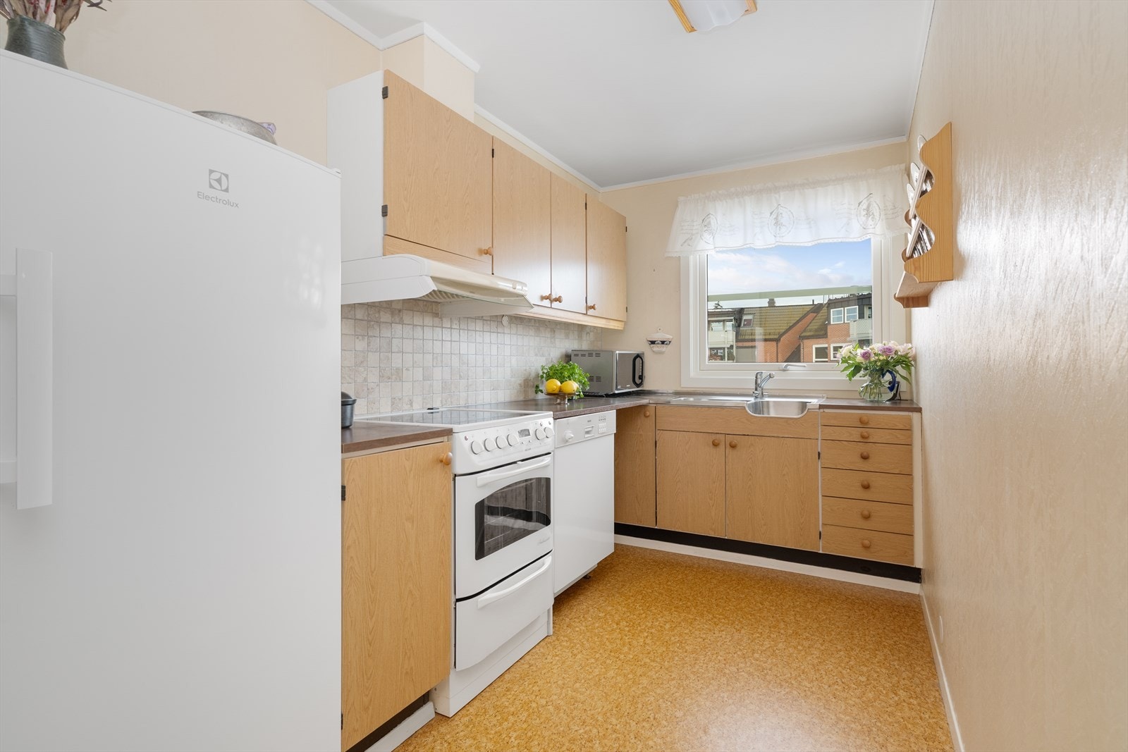 Trivelig kjøkken med god skapplass og fin utsikt til tunet. Kjøkken har innredning med slette fronter og benkeplate i laminat med flis over. Galleribilde