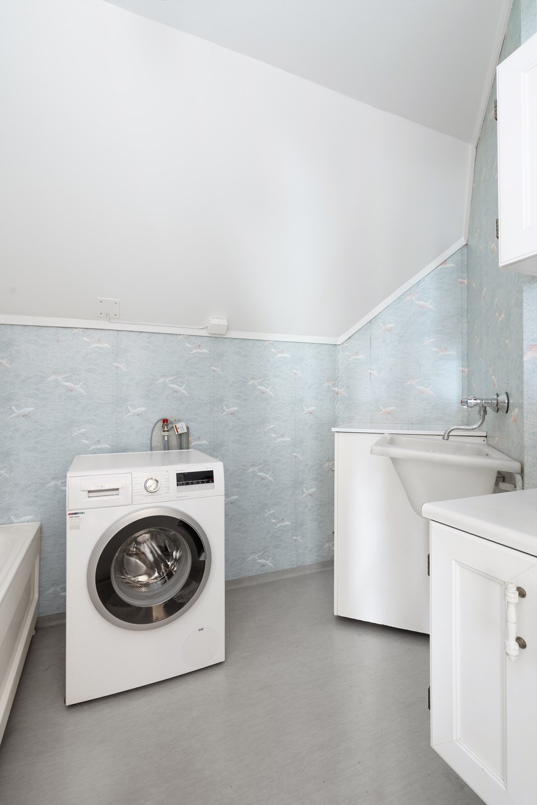 Eldre bad med vinylbelegg på gulv, våtromstapet på vegger og malte plater i tak. Galleribilde